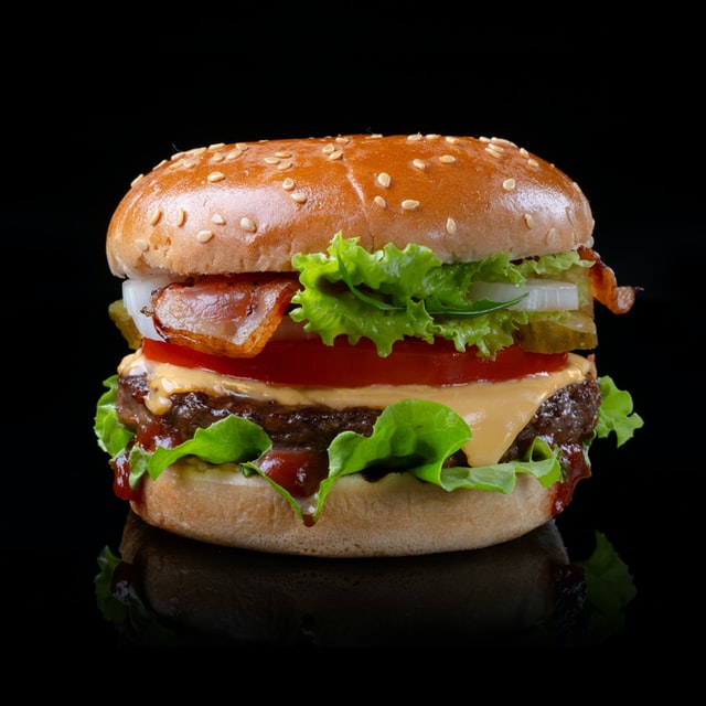 Bacon cheeseburger with lettuce and tomato.