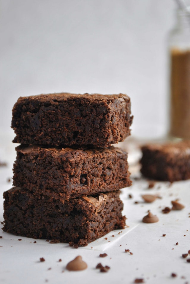 Crumbly chocolate brownies stacked on top of one another.