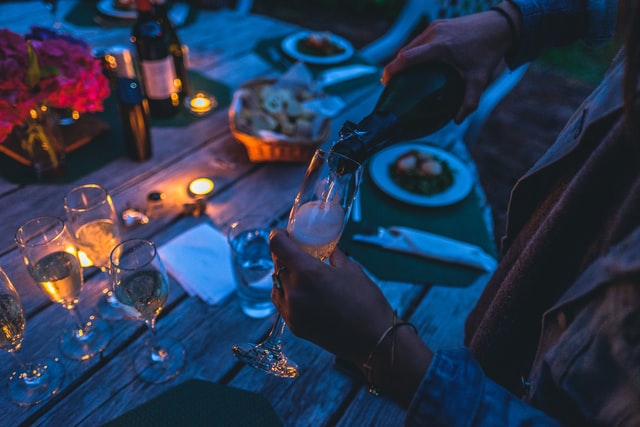 Pouring champagne at an outdoor candlelight dinner. 