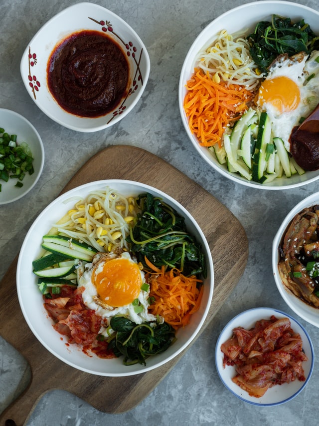 Bibimbap on a cutting board with other Korean dishes